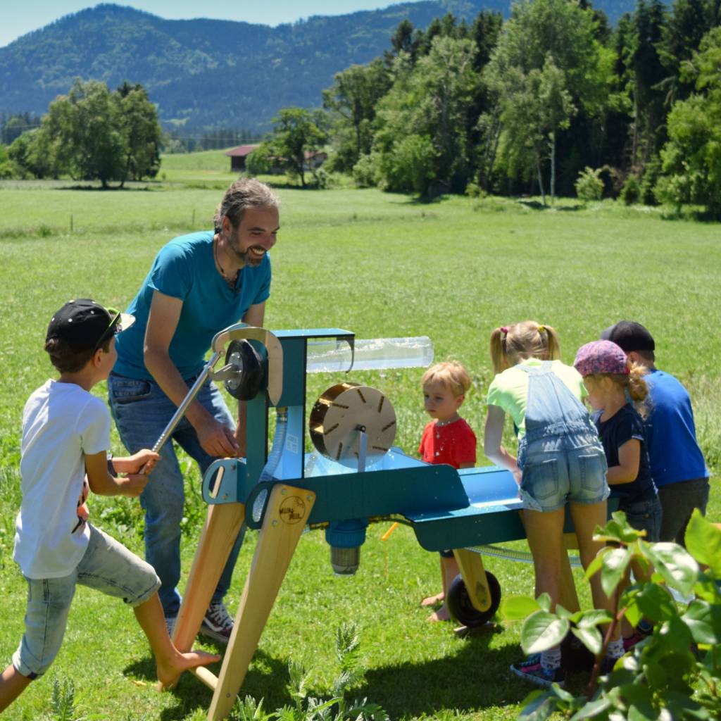 Der Erfinder Robert Jahnsmüller spielt mit Kindern am WELLENSPIELER Wasserspiel