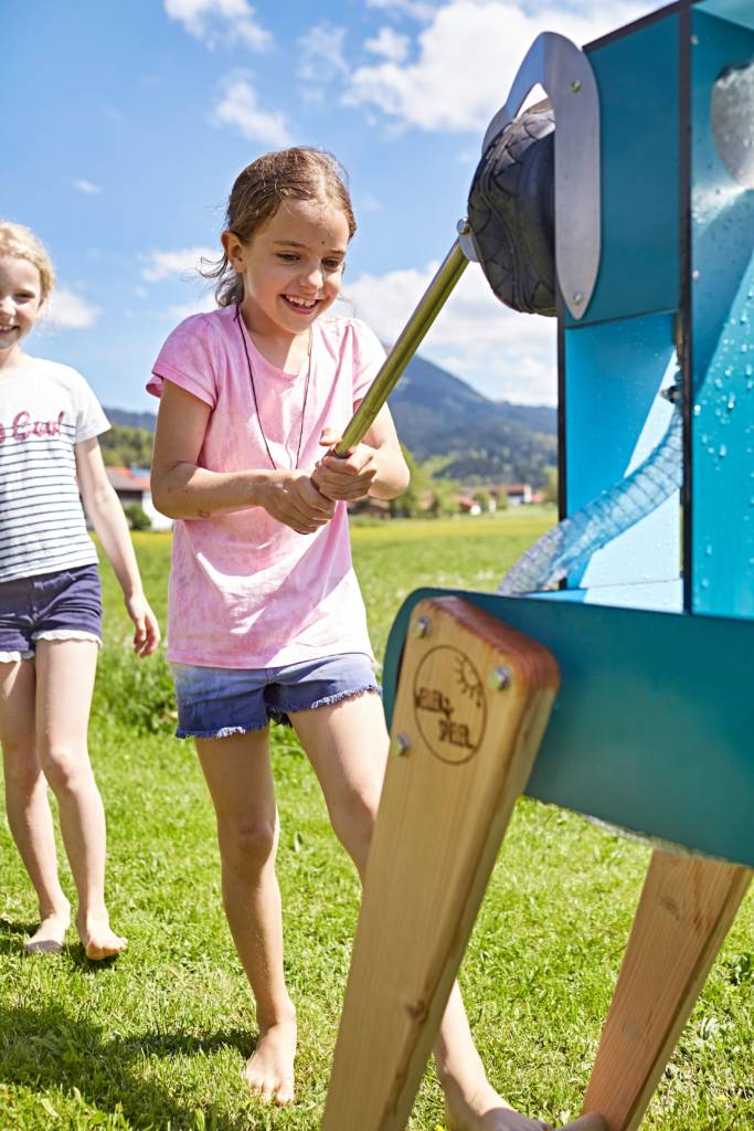 Mädchen pumpt Wasser am WELLENSPIELER Wasserspiel