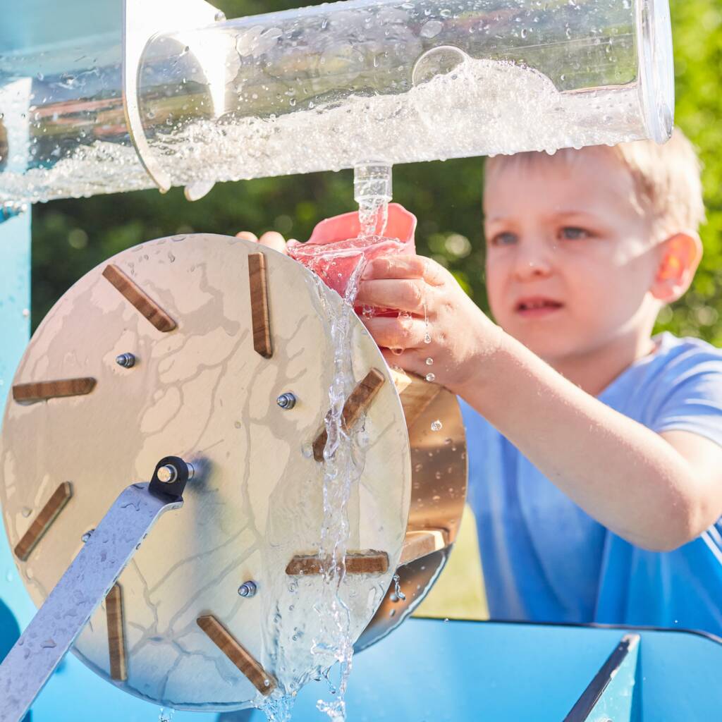 Kind beobachtet Wasser im transparenten Wellenrohr.